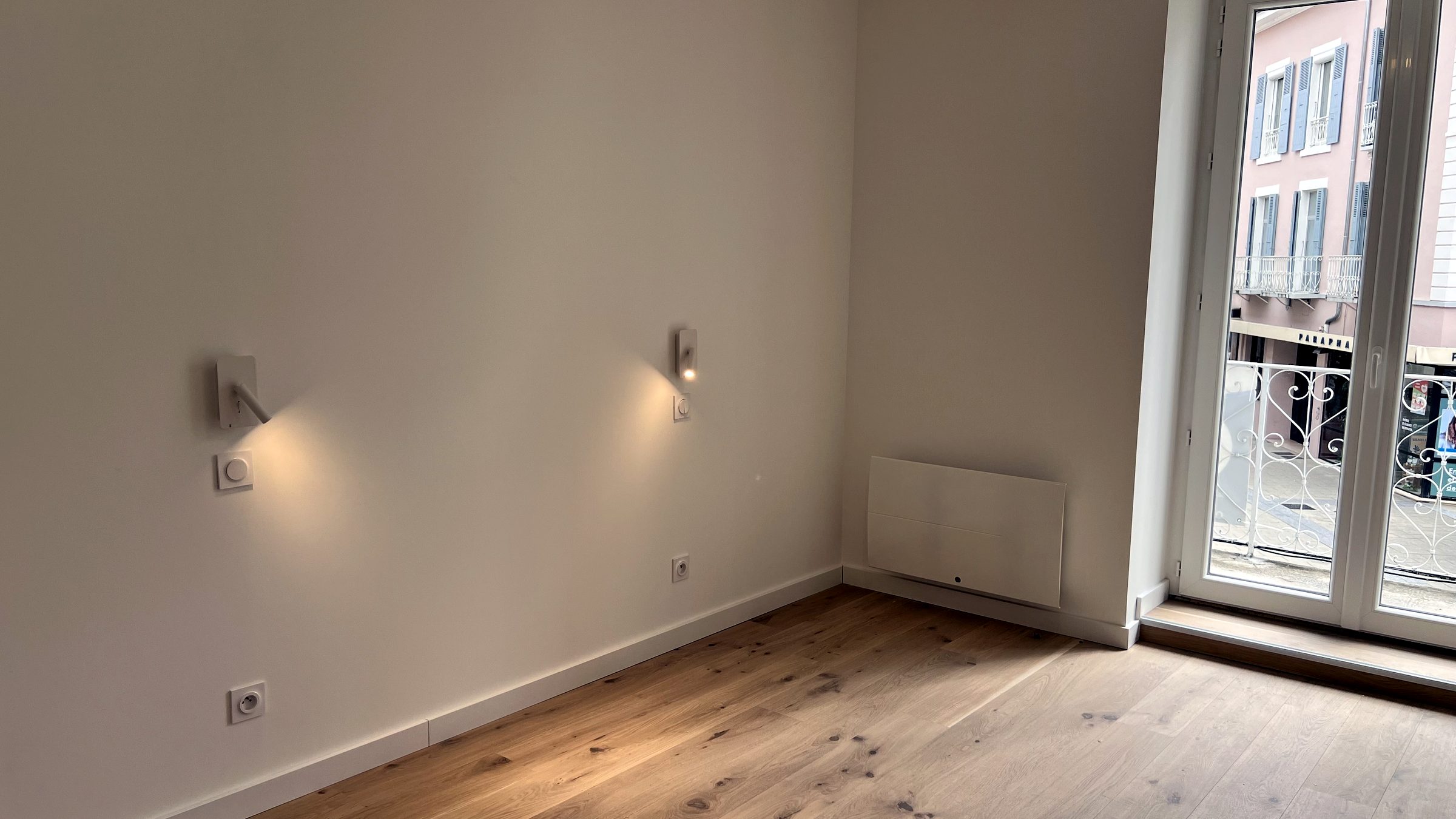 Chambre avec liseuses murales et porte-fenêtre
