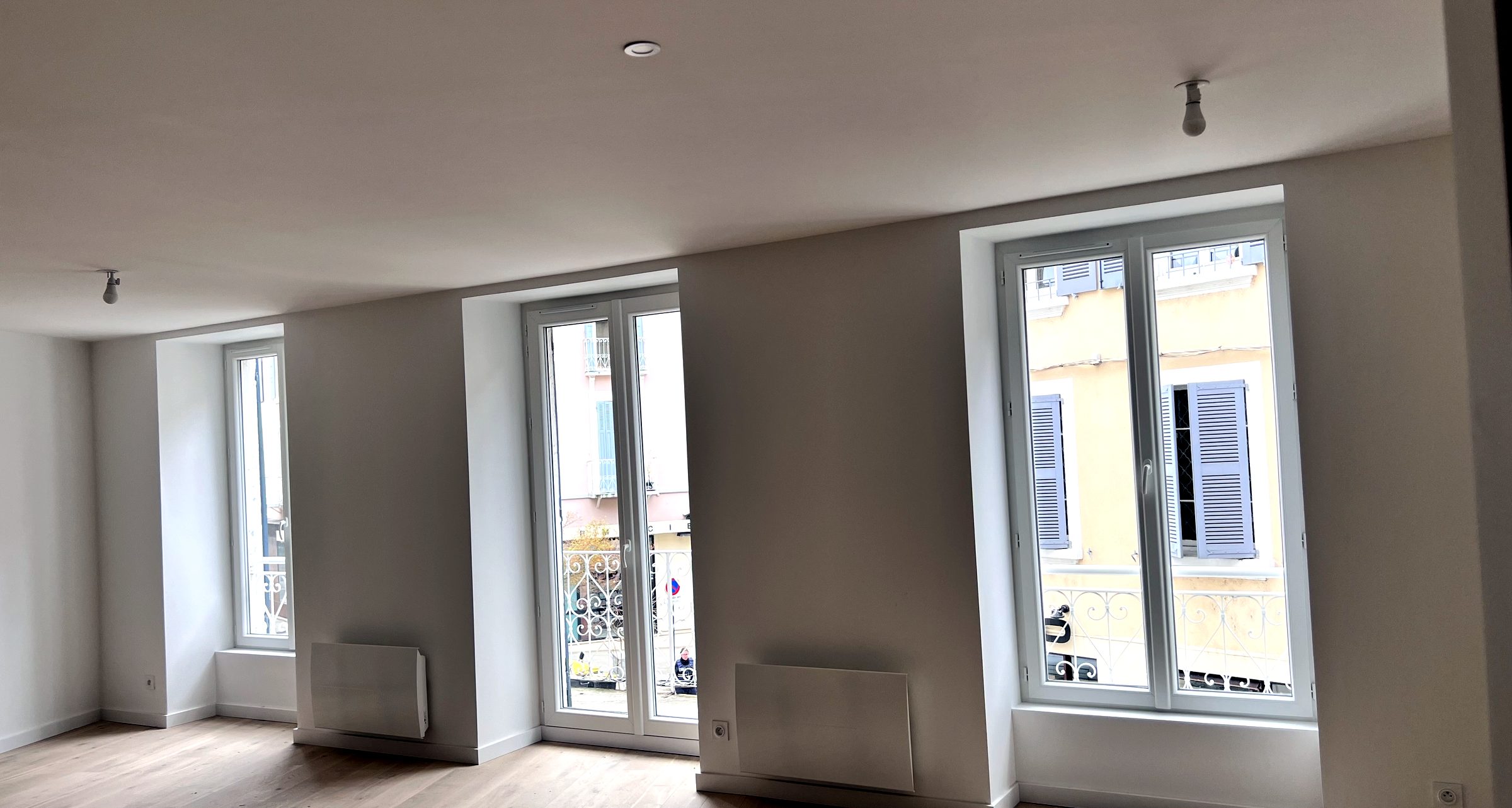 Séjour lumineux aux grandes fenêtres et parquet en chêne