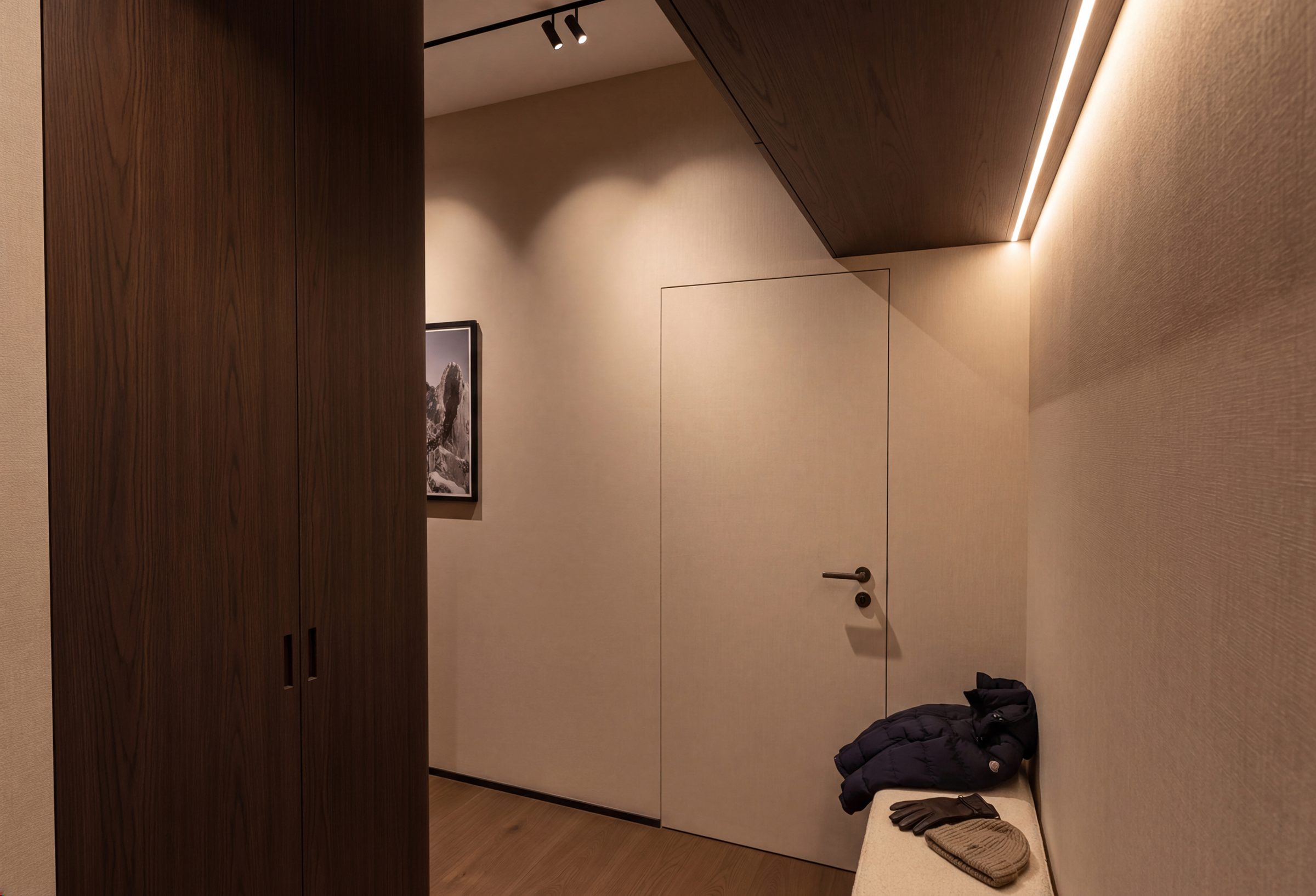 Entrée en bois sombre avec rangements intégrés et éclairage linéaire